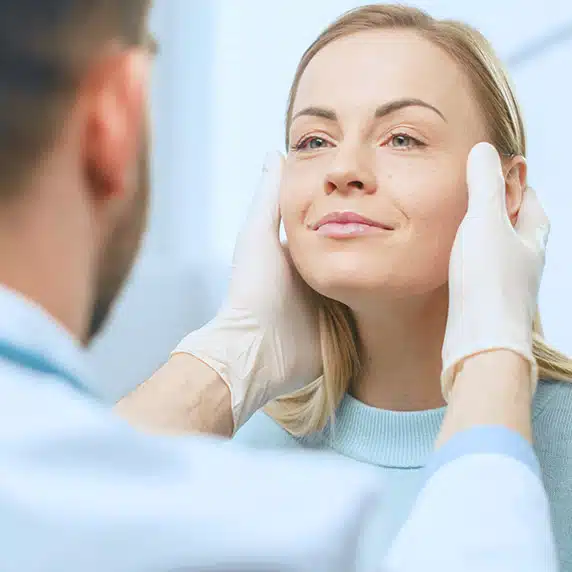 A woman in a consultation for a non-surgical facial procedure.