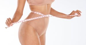 Woman measuring waist with tape, exemplifying body contouring options