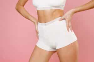 Woman showing the results of inner thigh liposuction.