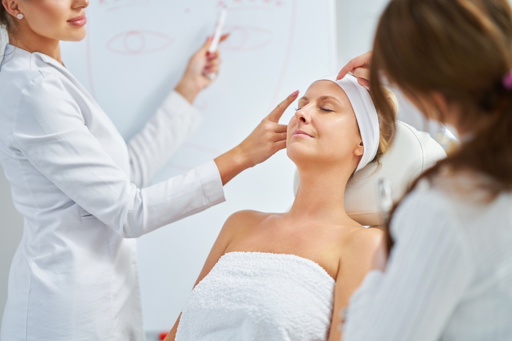 Patient receiving post-Botox consultation with professionals discussing facial treatment precautions and timing.